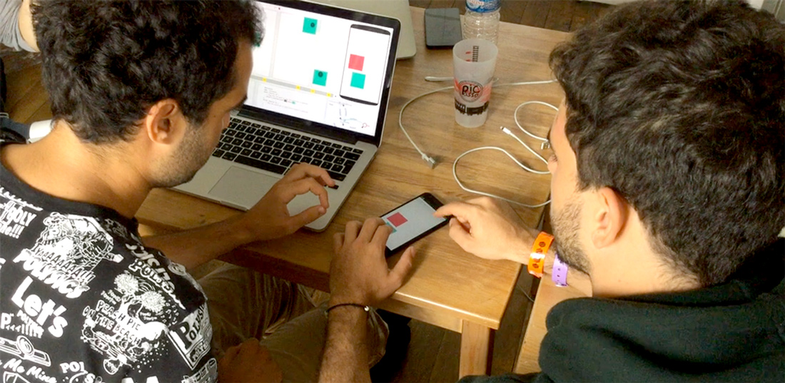 P4ds and P4dv working side-by-side collaboration on the final version of Interaction Two. On the right, the designer performs a “mimicking gesture” on-device to communicate the design. On the left, the developer performs a “mimicking gesture” off-device to understand the proposed design.